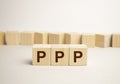 Three wooden cubes with letters PPP, stands for Praise Picture Push on white table