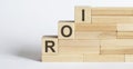 Three wooden cubes with letters ROI, means Return on Investment Royalty Free Stock Photo