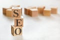 Three wooden cubes with letters SEO means Search Engine Optimization, on white table, more in background, space for text in Royalty Free Stock Photo