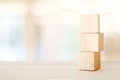 Three wooden cubes on table over blur abstract bokeh light background, banner with copy space for text