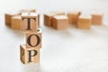 Three wooden cubes with word TOP, on white table, more in background, space for text in right down corner Royalty Free Stock Photo