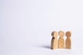 Three wooden figures of people stand together on a white background. Abstraction of a meeting, discussion, conversation. People d Royalty Free Stock Photo