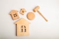 Three wooden houses and a hammer of the judge on a white background. Court cases on property and real estate. Confiscation and nat Royalty Free Stock Photo