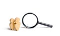 Three wooden human figure stands near a magnifying glass on a white background. The concept of the search for people and workers. Royalty Free Stock Photo