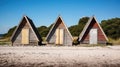 Three wooden huts on a sandy beach on a sunny day. Small houses or beach cabins Royalty Free Stock Photo