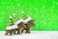 Three wooden reindeer for christmas on a green background with s