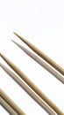 Three wooden sharp toothpicks on a white mirror background. Royalty Free Stock Photo