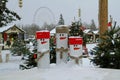 Three wooden snowmen in snow on the background of `Christmas light` festival in VDNKh in Moscow