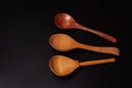 Three wooden spoons close-up, on a black background Royalty Free Stock Photo