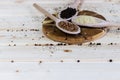 Three wooden spoons with spices, coriander, peppercorns and rice on a wooden background. Rustic look and copy space Royalty Free Stock Photo