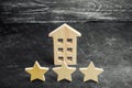 Three wooden stars and a house. Three star hotel or restaurant. Review of the critic. Quality of service and level of service.