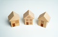 Three wooden toy houses. Buying and selling housing. Property insurance. Real estate market review. Foreign real estate and