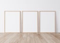 Minimal frame mock up interior, Three wooden vertical frames Standing on parquet floor with white background Royalty Free Stock Photo