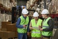 Three workers doing inspection in warehouse holding clipboard Royalty Free Stock Photo