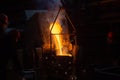 three workers filling ladle with molten steel