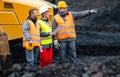 Three workers in quarry with heavy machinery