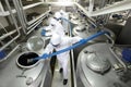 Three workers working at large silver tanks in plant