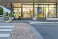 three workmen in flouro vests blurred walking to work past colourful display windows department store on city street