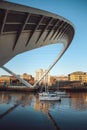 Three yachts sailing under the Gateshead Millennium Bridge on River Tyne