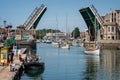Three yachts sailing under Weymouth bridge with bridge fully open in Weymouth Harbour, Dorset, UK
