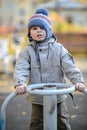 three-year-old boy rides a swing on the playground Royalty Free Stock Photo