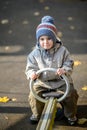 three-year-old boy rides a swing on the playground Royalty Free Stock Photo