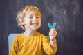 Three-year old boy shows myofunctional trainer. Helps equalize the growing teeth and correct bite, develop mouth Royalty Free Stock Photo