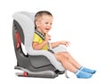 Three-year-old boy sits in an automobile children`s chair Royalty Free Stock Photo