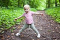 Three-year-old Caucasian girl runs and plays in the park on a path Royalty Free Stock Photo