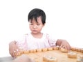 A three-year-old Chinese girl in front of a white background is playing Chinese chess Royalty Free Stock Photo