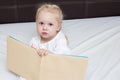 Three year old girl reading a book