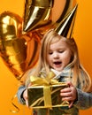 Three years girl toddler kid with gold presents balloons and birthday cap celebrating Royalty Free Stock Photo