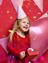 Adorable pretty girl with pink balloons and red present gift and birthday cap Royalty Free Stock Photo