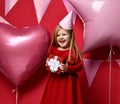 Adorable pretty girl with pink balloons and red present gift and birthday cap Royalty Free Stock Photo