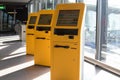 Three yellow airport check-in portals at schiphol airport