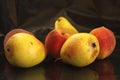 Three yellow autumn pears and three peaches on a black background Royalty Free Stock Photo