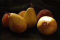 Three yellow autumn pears and three peaches on a black background Royalty Free Stock Photo