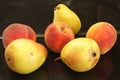 Three yellow autumn pears and three peaches on a black background Royalty Free Stock Photo