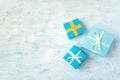 three Yellow and blue gift box with white ribbon and bow on light blue watercolor pastel table background. Minimal festive winter Royalty Free Stock Photo