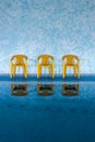 Three yellow chairs at swimming pool