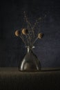 Three yellow dried flowers in a small vase