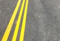 Three yellow lines in dark tarmac road with space for copy Royalty Free Stock Photo