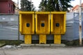 Three yellow phone boothes with blue phones