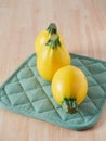 three yellow round zucchini on green kitchen towel Royalty Free Stock Photo