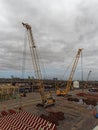 Three Yellow Tracked Mobile Cranes working on Anchor Handling equipment on one of the Quays of Rio Old Port.