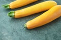 Three yellow zucchini on kitchen table. Whole raw courgettes Royalty Free Stock Photo