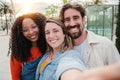Three young adult friends smiling taking a selfie portrait and having fun together. Group of multiracial cheerful people Royalty Free Stock Photo