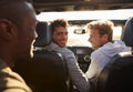 Three young adult men driving with sunroof open, back view