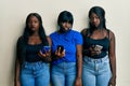 Three young african american friends using smartphone depressed and worry for distress, crying angry and afraid