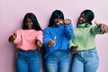 Three young african american friends wearing wool winter sweater approving doing positive gesture with hand, thumbs up smiling and Royalty Free Stock Photo